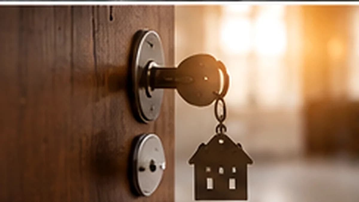 Una chiave nella serratura con un portachiavi a forma di casa